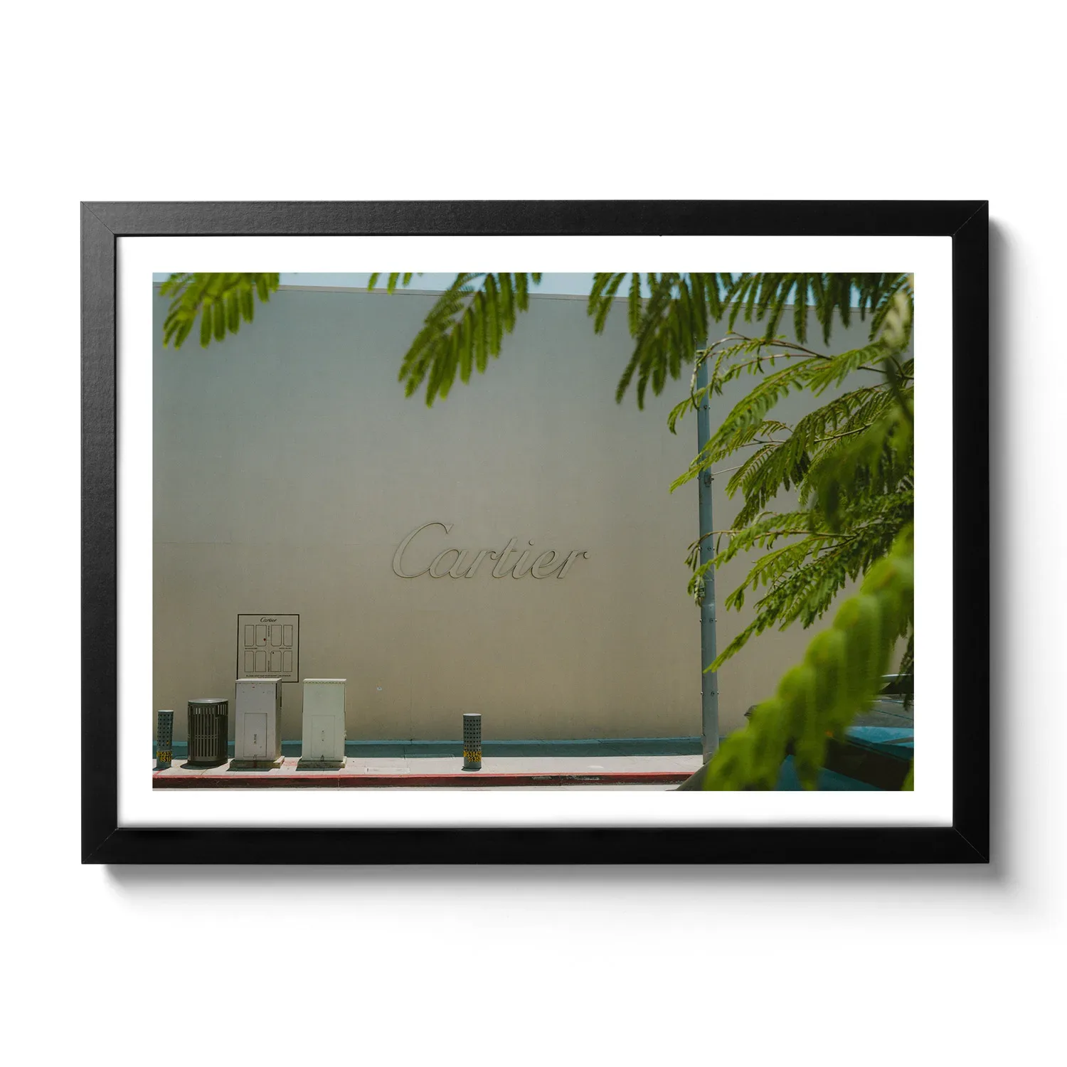 Cartier Bildaufnahme von einer beigen Wand mit großem Cartier Schriftzug.