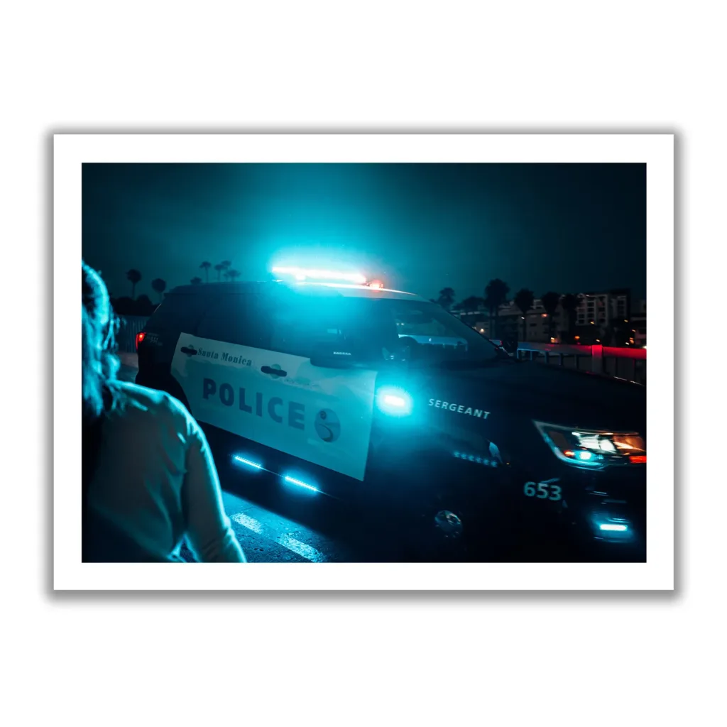 Bildaufnahme eines amerikanischen Polizei Autos bei Nacht, dass gerade die Sirene aktiviert hat. Blauer Neonlook.