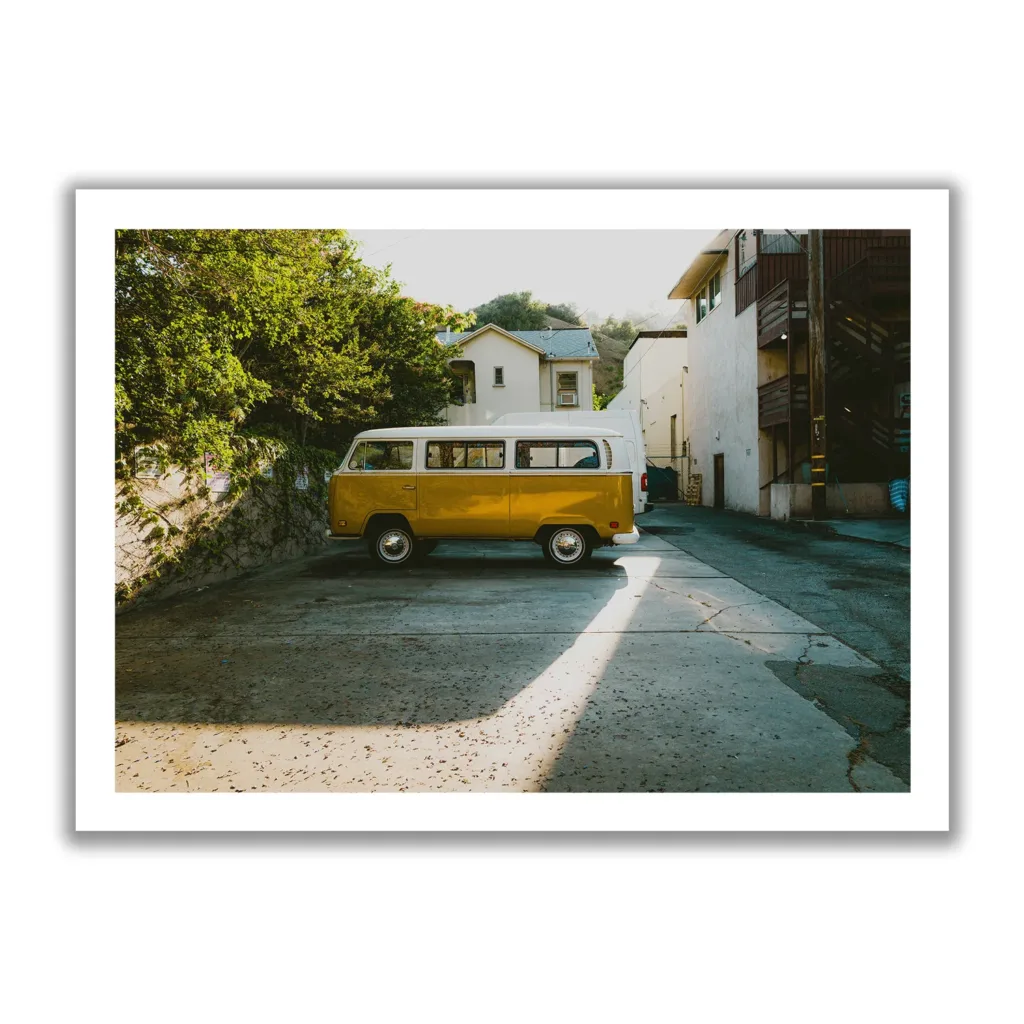 Alter gelber VW Buli der in einer Seitenstraße parkt, dazu cooler Lichteinfall (Vintage Look)