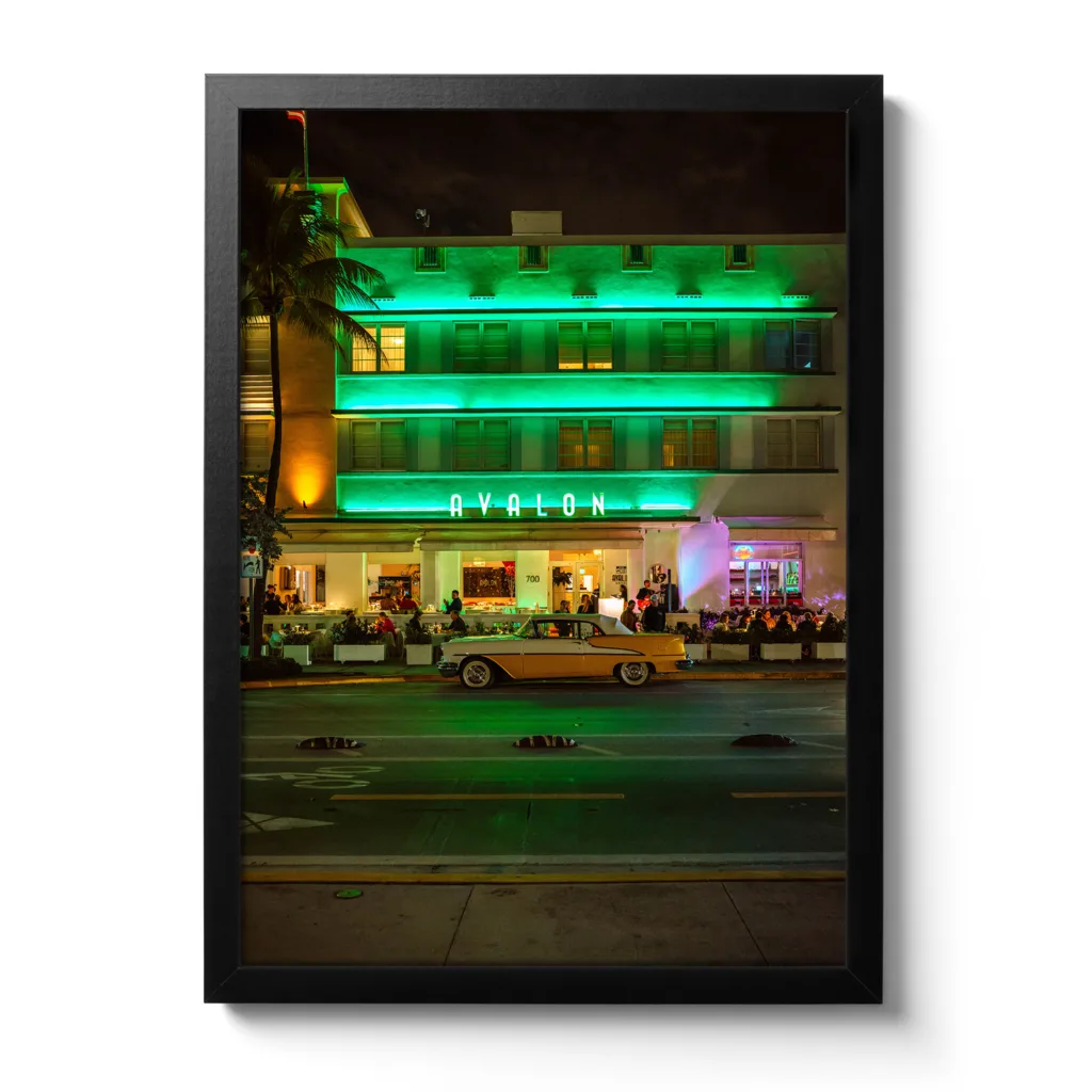 Bildaufnahme im Hochformat vom Avalon Hotel Miami am Ocean Drive mit einem gelben Oldtimer davor.
