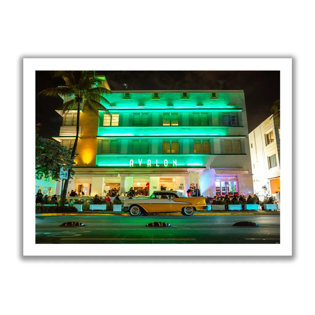 Landscapeaufnahme vom Avalon Hotel Miami am Ocean Drive mit einem gelben Oldtimer davor.