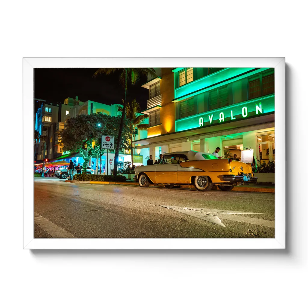 Bildaufnahme vom Avalon Hotel Miami am Ocean Drive mit einem gelben Oldtimer davor.