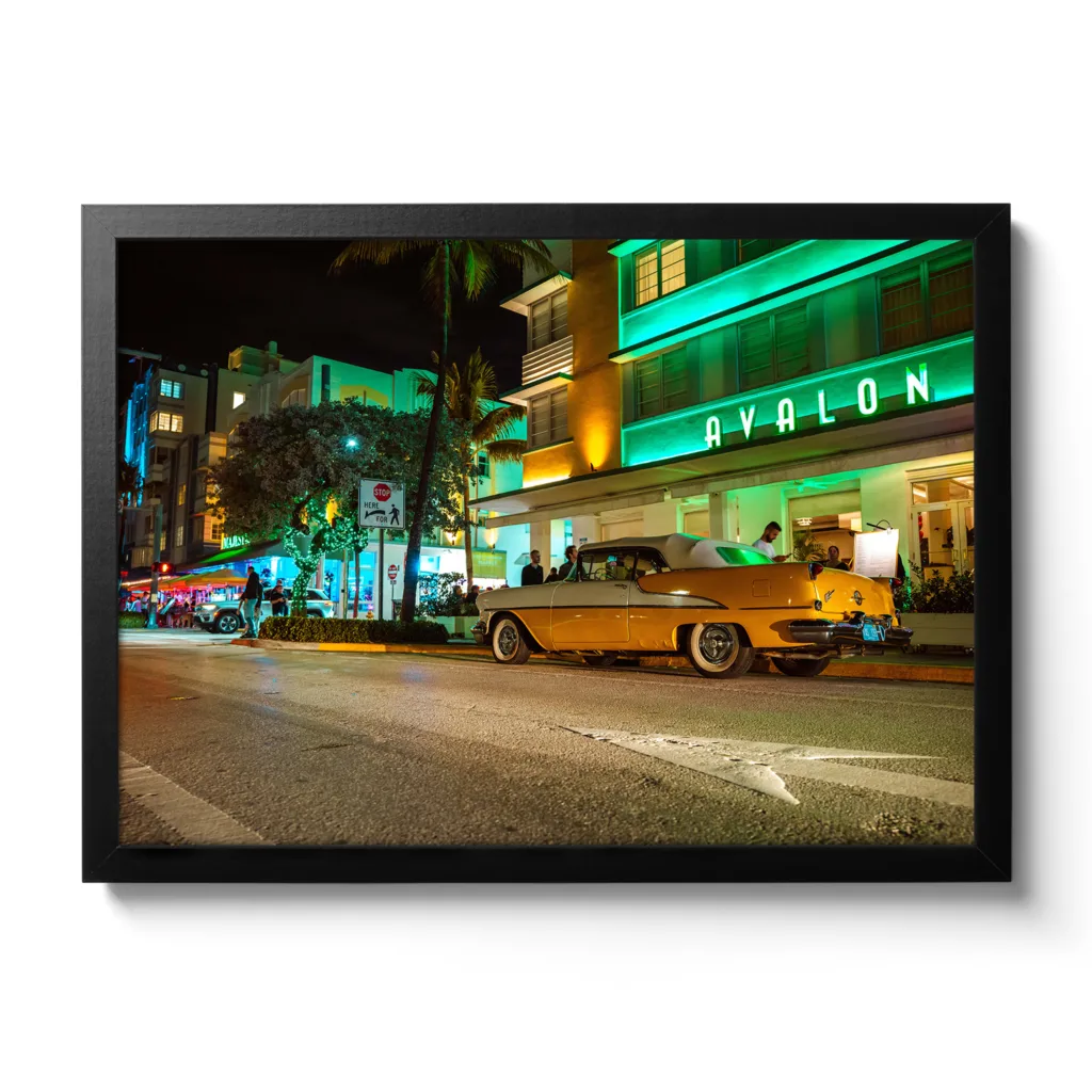 Bildaufnahme vom Avalon Hotel Miami am Ocean Drive mit einem gelben Oldtimer davor.