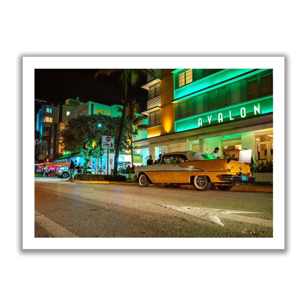 Bildaufnahme vom Avalon Hotel Miami am Ocean Drive mit einem gelben Oldtimer davor.