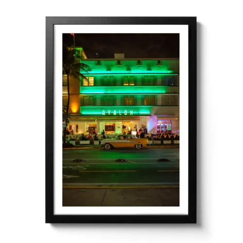 Bildaufnahme im Hochformat vom Avalon Hotel Miami am Ocean Drive mit einem gelben Oldtimer davor.