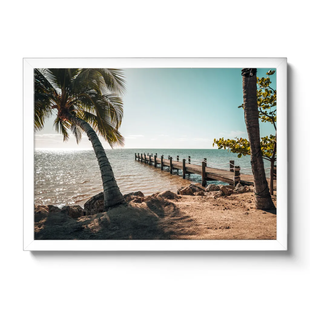 Bildaufnahme eines Steges der ins Meer hinausgeht und links und rechts befinden sich Palmen. Vormittagsstimmung mit Sonne und Meer.