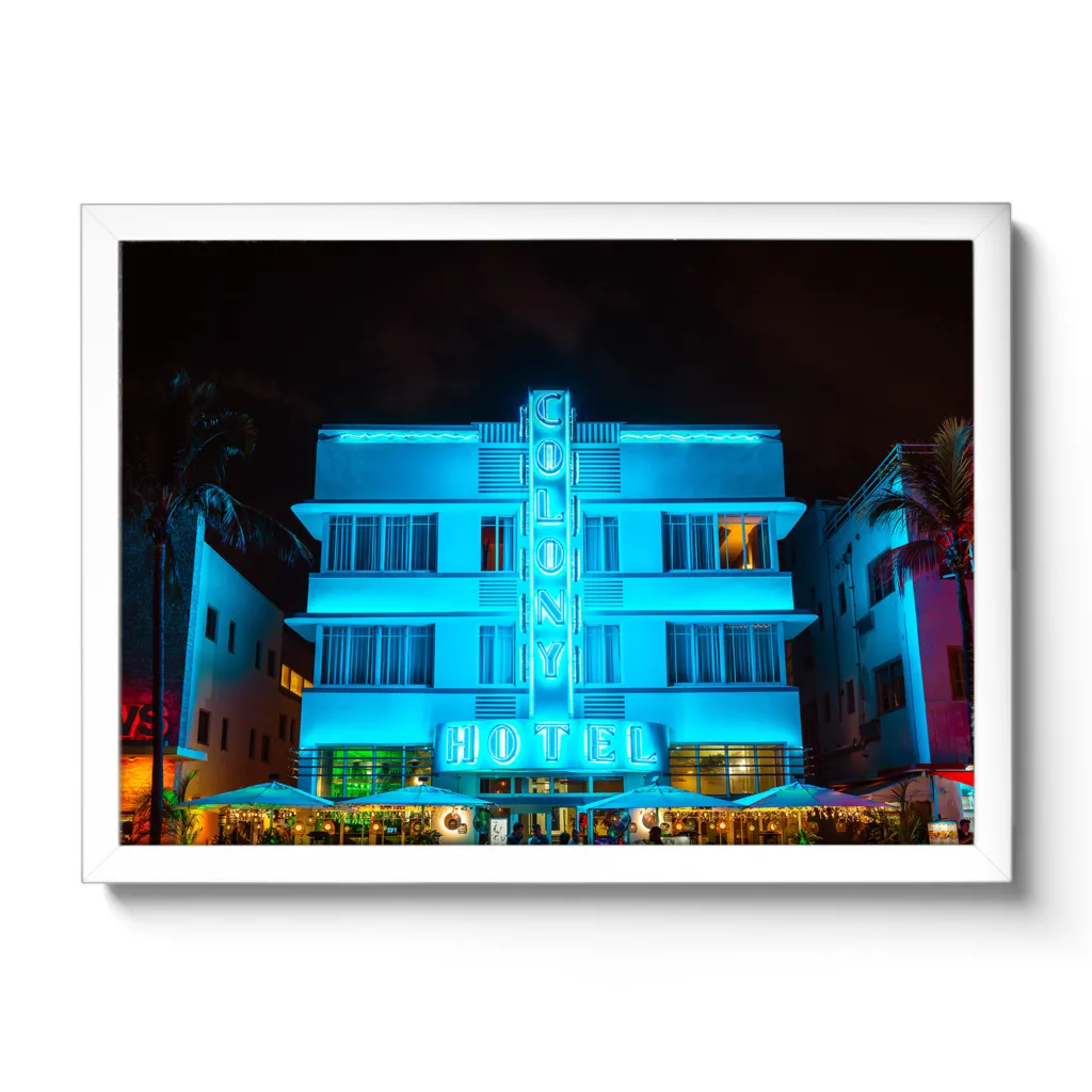 Bildaufnahme bei Nacht vom Colony Hotel Miami. Blaue Neonlichter und Palmen