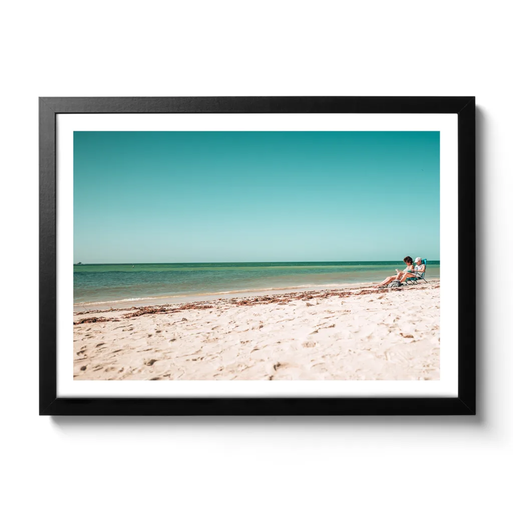 Strandansicht von Bahia Honda National Park, blaues Meer, weißer Sandstrand und zwei Personen im Campingsessel