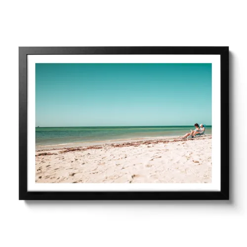 Beach view of Bahia Honda National Park, blue sea, white sandy beach and two people in a camping chair