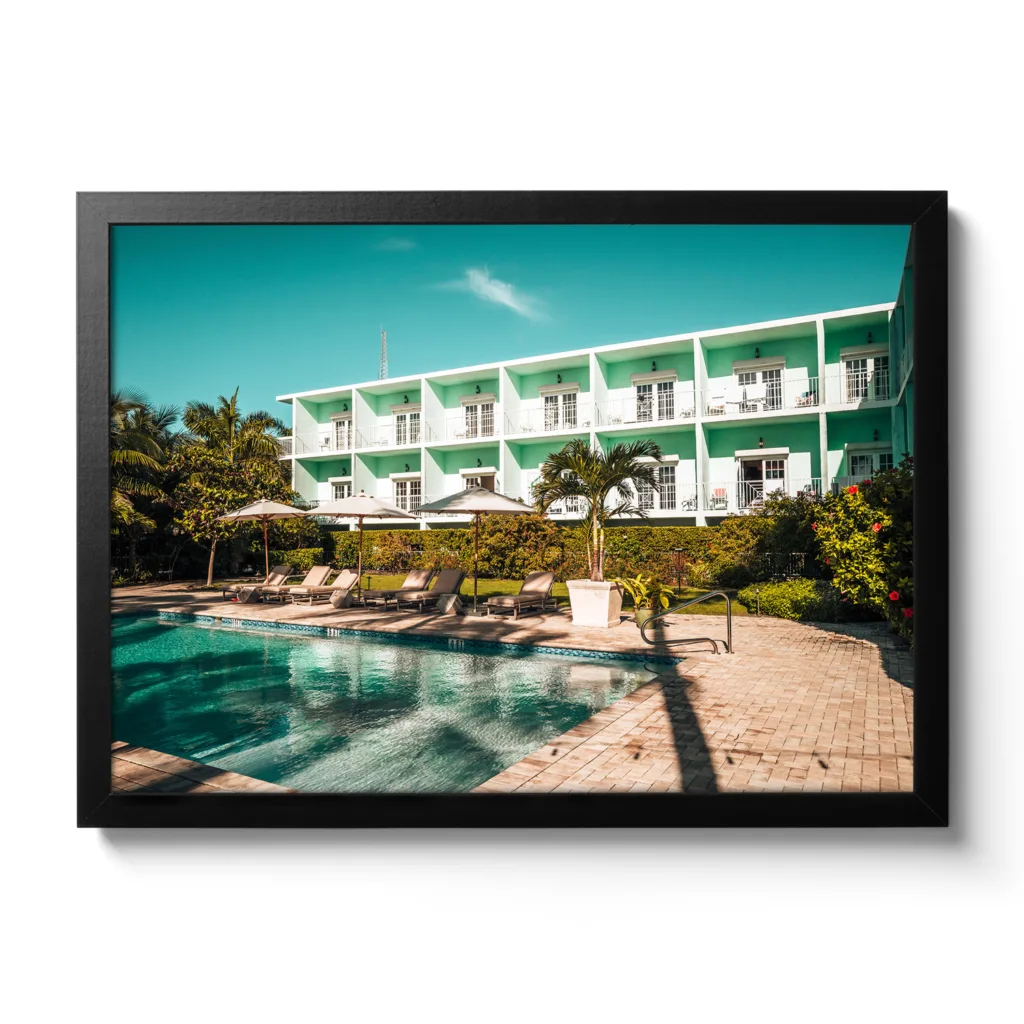 Bildaufnahme des Pool-Bereiches des Grassy Flat Hotel. Blauer Himmel, Pool und Liegen. Morgenansicht.