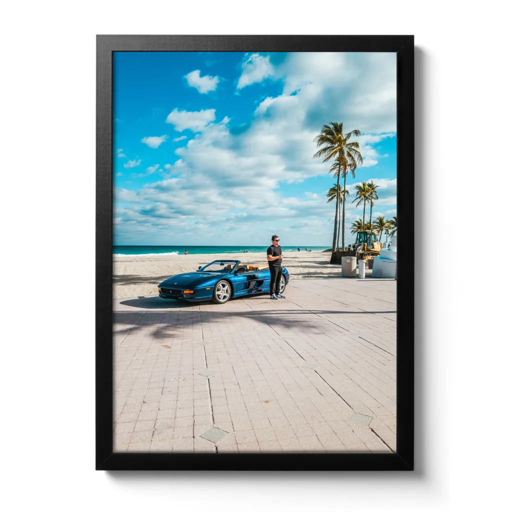 Junger Mann steht vor einem blauen Ferrari am Strand von Fort Lauderdale.