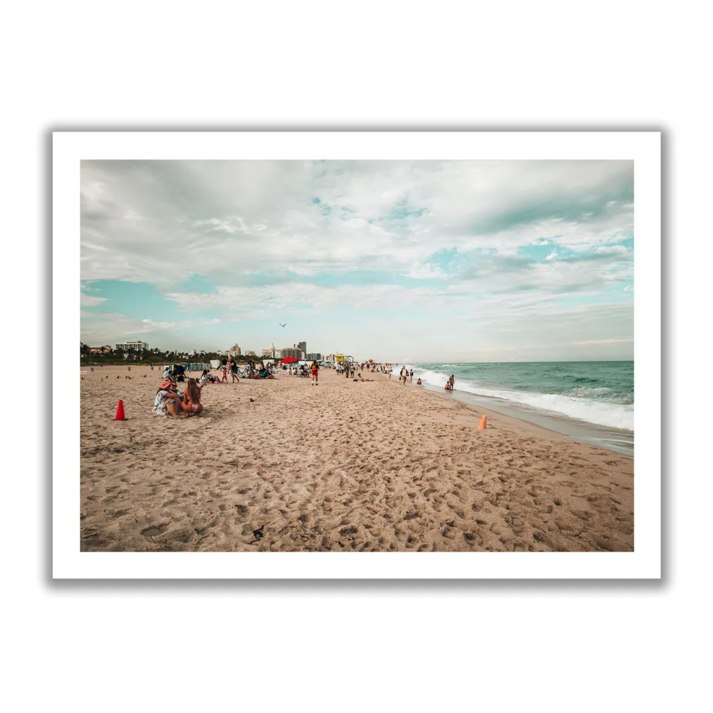 Strandaufnahme von Miami Beach. Leute die chilln am Strand sowie blaues Meer