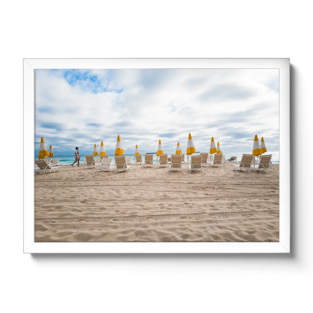 Bildaufnahme von einem leeren Strand, wo alle gelben Schirme zugespannt sind.