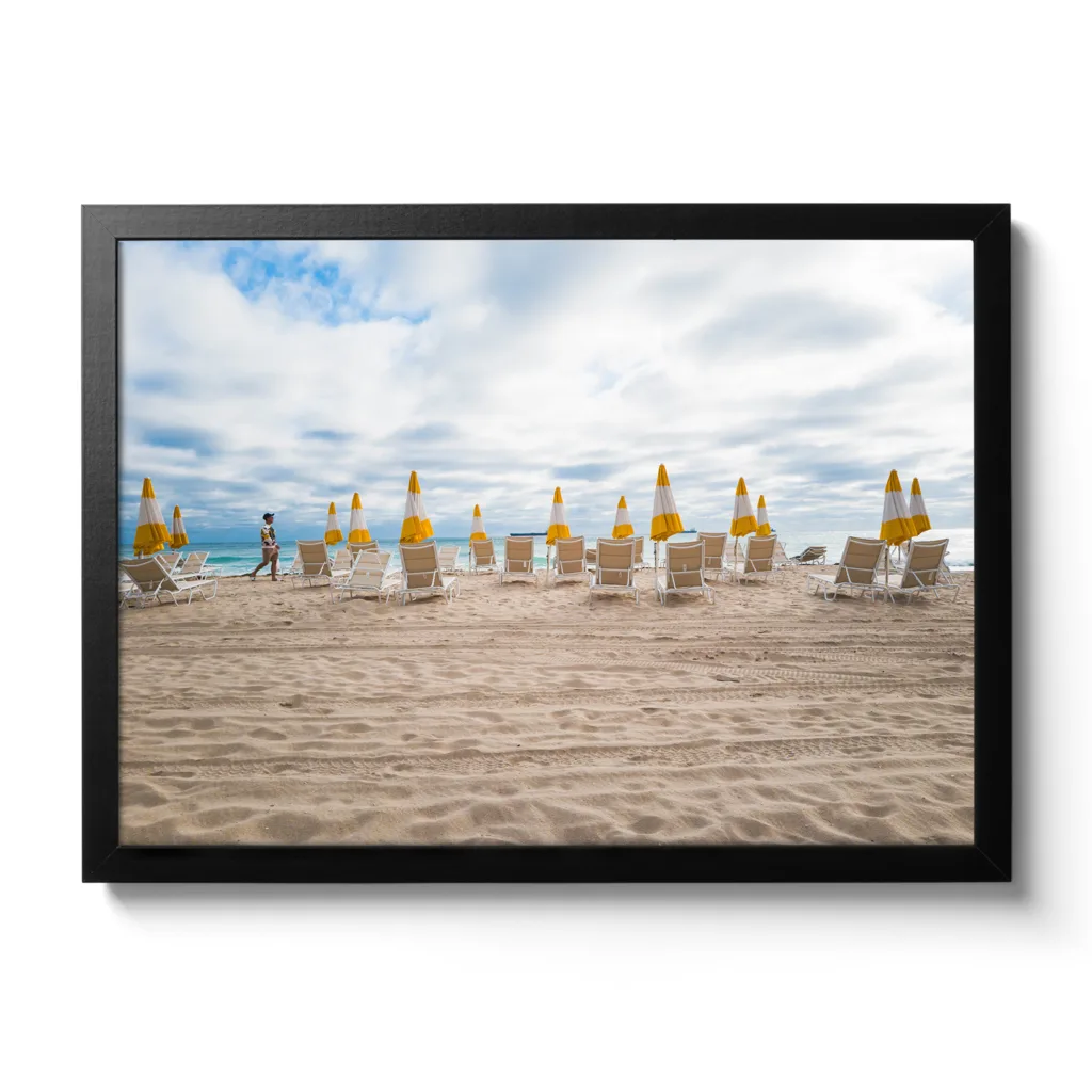 Bildaufnahme von einem leeren Strand, wo alle gelben Schirme zugespannt sind.
