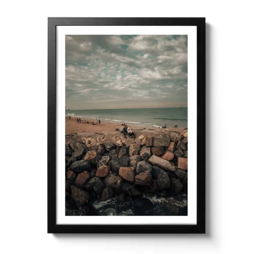 Bildaufnahme von einem Vater der seinen Sohn im Arm hält und auf steinigen Felsen sitzt.