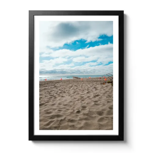 Bildaufnahme vom Strand in Fort Lauderdale wo man ein Surfbrett sieht. Im Hintergrund sieht man das Meer.