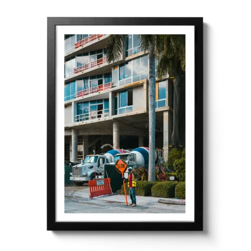 Roadworks photo with a young man holding up a sign warning road users to drive slowly.