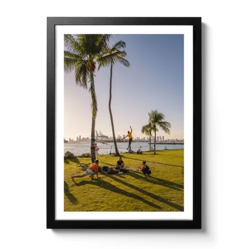 Bildaufnahme vom South Pointe Miami, wo ein Mann auf einer Slackline steht und davor eine Yoga-Gruppe.