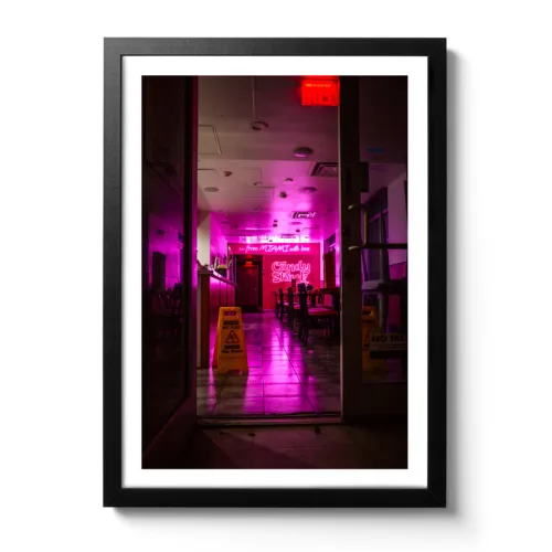 Bildaufnahme von einer leeren Bar, die mit Neonlichtern glänzt durch den nassen Boden.